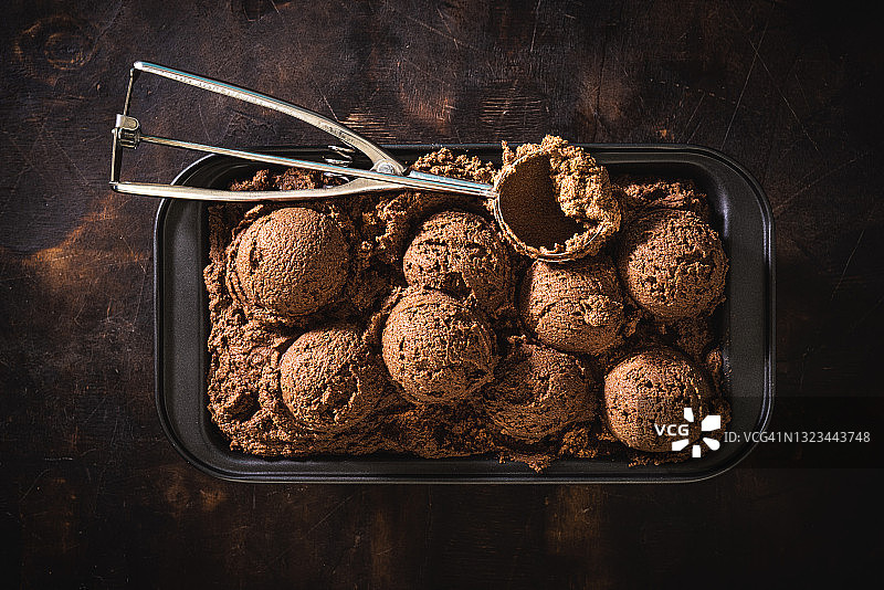 巧克力冰淇淋球在冰淇淋托盘和薄荷叶在深色的木头图片素材