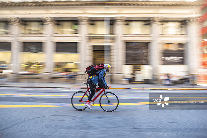 中年男性自行车信使骑在城市街道上图片素材