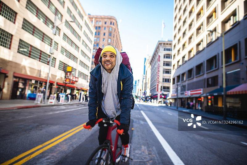 微笑的中年男性自行车交付在市中心区图片素材