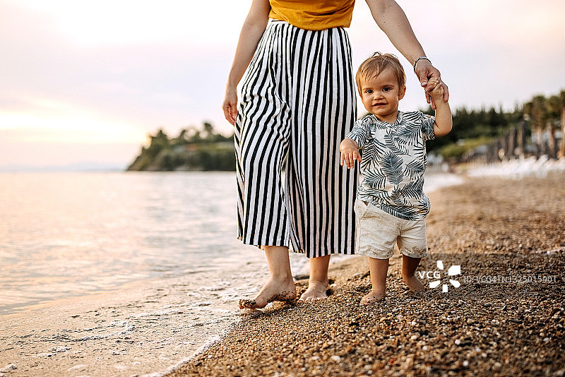 可爱的小男孩和他的妈妈在海滩上图片素材