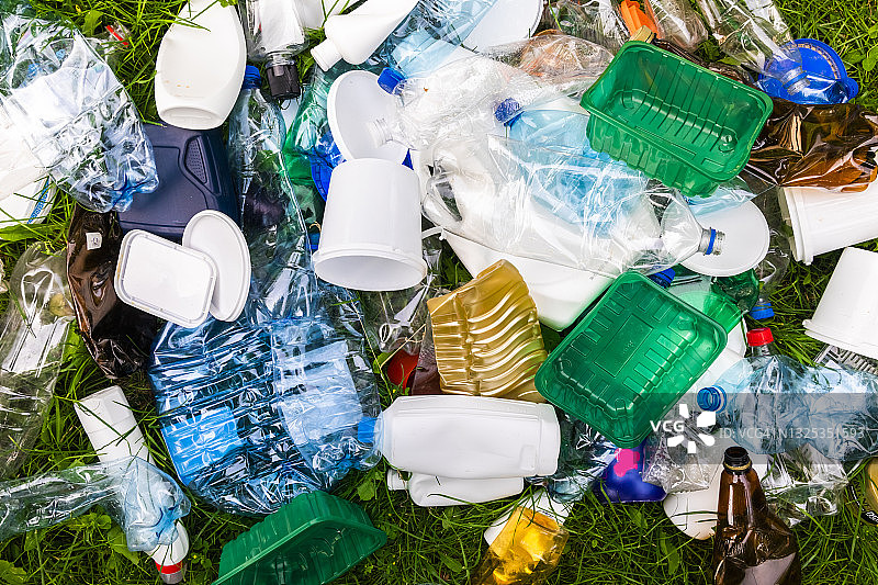 草地上有各种各样的塑料垃圾。塑料回收。图片素材