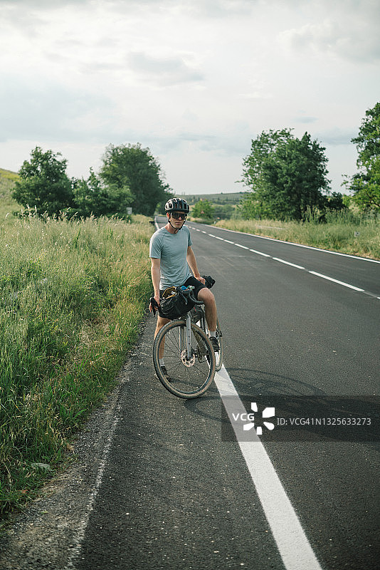 骑公路自行车的人在阳光明媚的乡村道路上放松图片素材