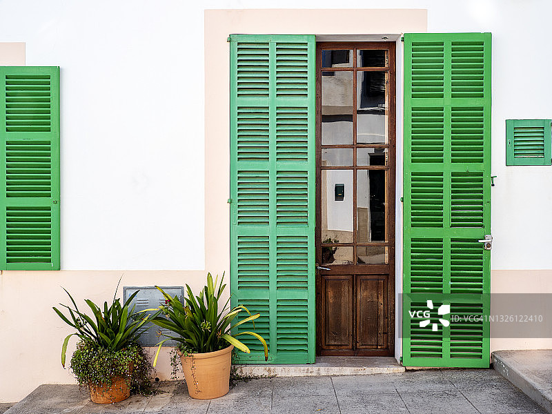 典型的马略卡岛房屋立面，带有花盆和彩色窗户。图片素材
