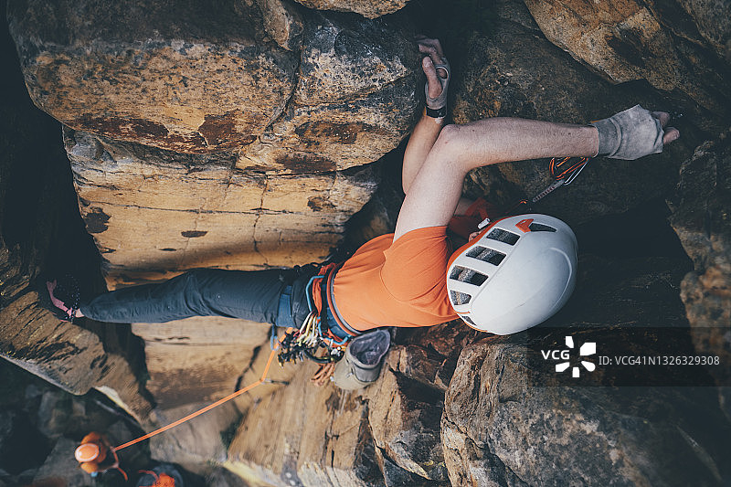 头顶拍摄的一个男性攀岩者放置安全设备在岩石附近的弗农，BC图片素材