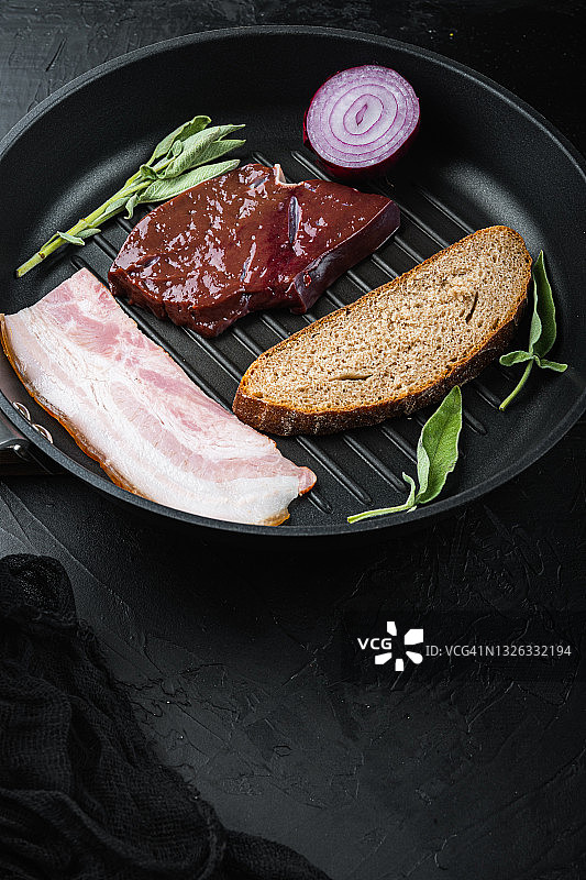 生牛肝与培根片放在烤盘上，表面为黑色图片素材
