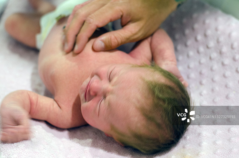 新生婴儿在换尿布台上图片素材