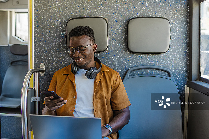 乘坐公共交通的乘客正在用笔记本电脑和手机工作图片素材