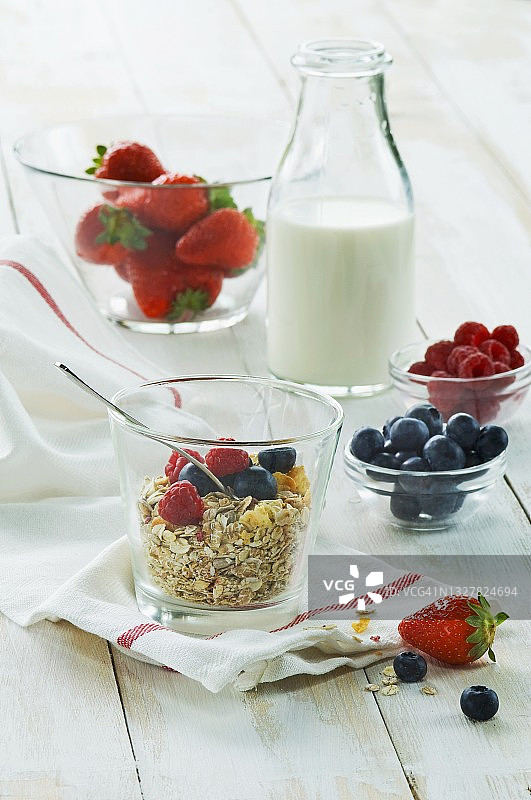 健康早餐:木桌上放着新鲜水果和牛奶，草莓，覆盆子，蓝莓图片素材