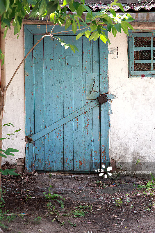 一扇带锁的木门通往一个废弃的村庄谷仓图片素材