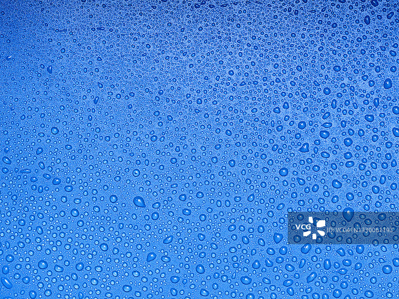 蓝色背景上的水滴和飞溅的完整框架。图片素材