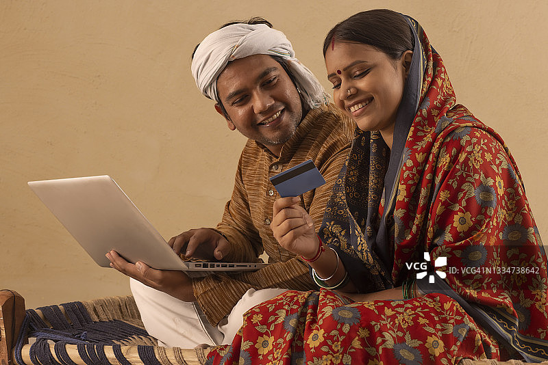 一个农村的丈夫和妻子坐在一起做网上交易图片素材