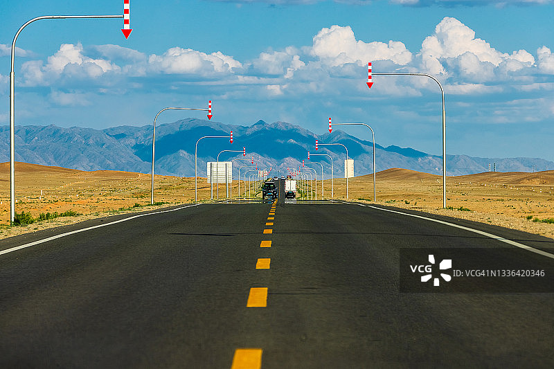 通往山区的高等级道路，沿路设置路标。中国新疆维吾尔自治区。图片素材