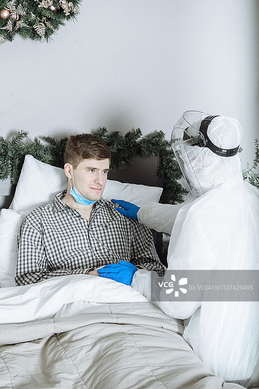 一名穿着防护服的医生正在检查一名感染了冠状病毒covid-19的病人图片素材