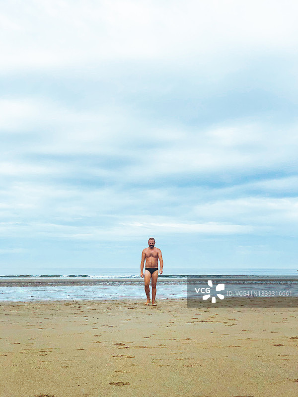 一个穿着泳衣从海边走出来的人图片素材