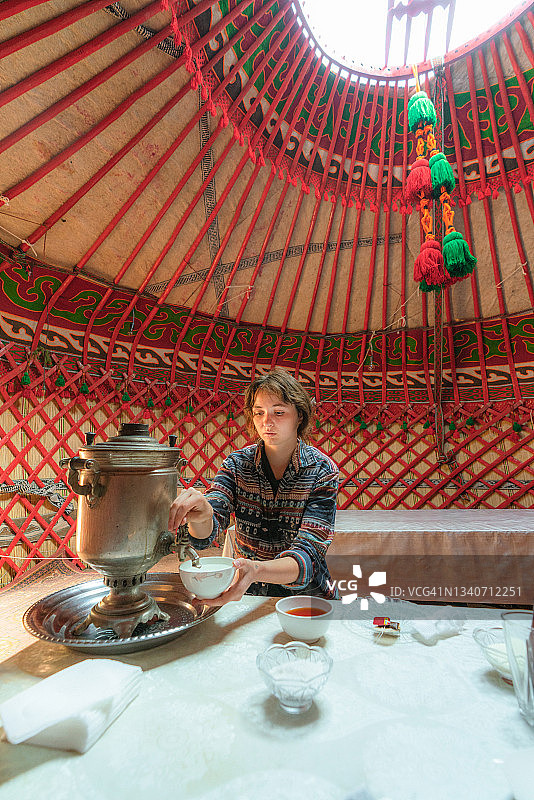 女人在蒙古包里用茶炊喝茶图片素材