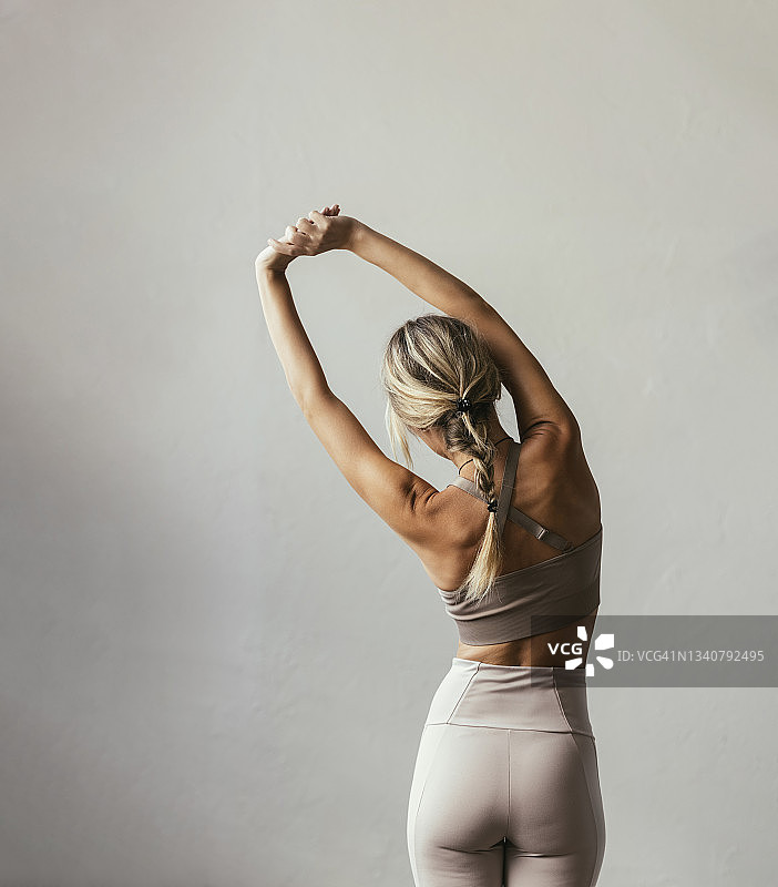 一个年轻的金发白种女人在伸展身体图片素材