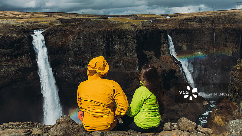 女人和男人在冰岛美丽的彩虹瀑布感受大自然的力量图片素材