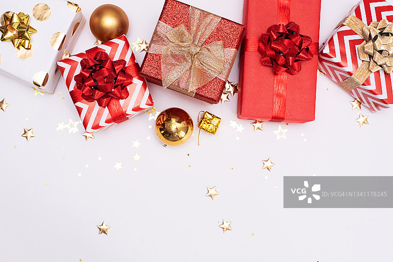 冬天的图案与小圣诞礼物包在红色的纸在白色的背景。图片素材