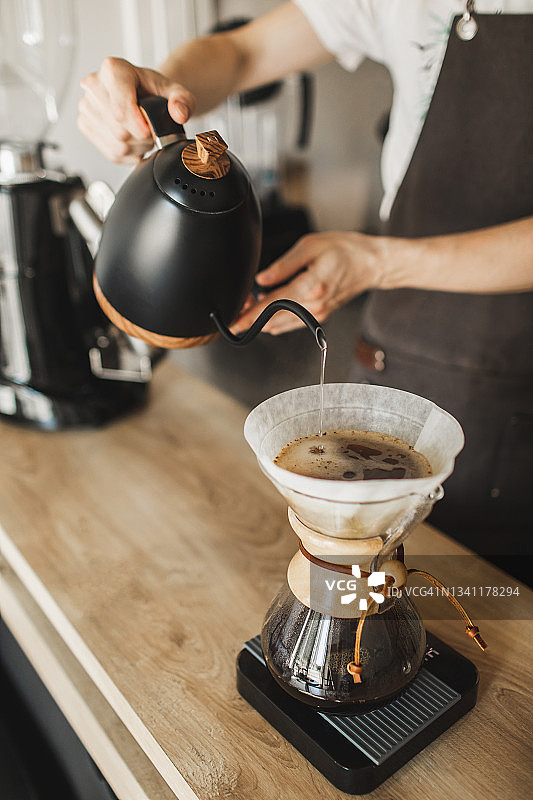 咖啡师手工将水从水壶倒入过滤咖啡机chemex图片素材