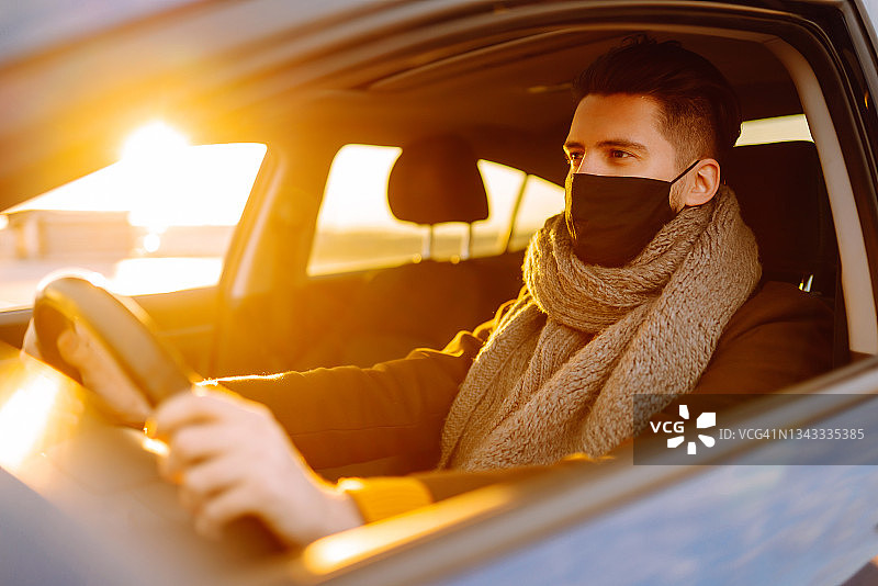 在疫情期间戴着医用口罩开车的人，戴着口罩的司机，可以保护自己免受病毒感染。图片素材