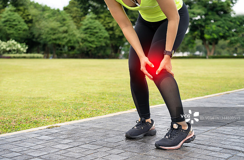 膝盖疼痛。运动损伤，女性在户外运动时膝盖疼痛。女子跑步运动员跑步膝盖损伤的研究。图片素材