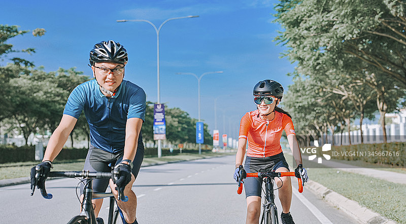 亚洲的中国夫妇喜欢在周末早上一起骑公路自行车图片素材