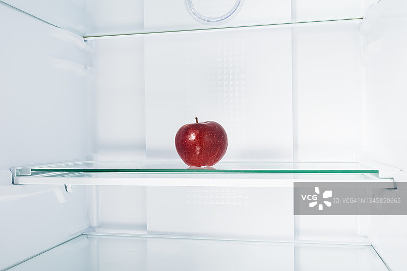 红苹果放在冰箱的玻璃架子上图片素材