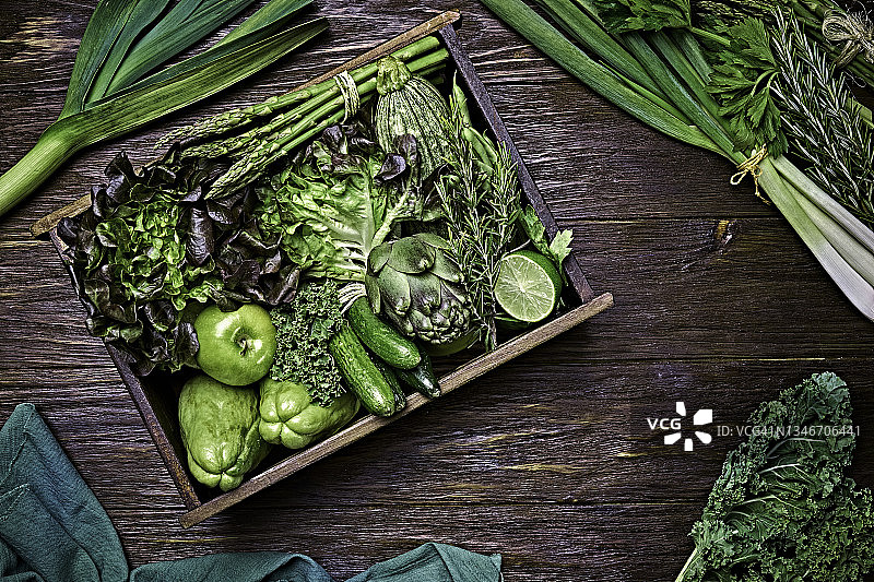 表顶视图背景变化绿色蔬菜排毒和碱性饮食。放在带有框架的木制桌子上的板条箱里图片素材