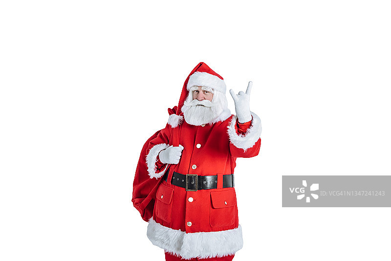 圣诞老人与袋礼物显示岩石手势在白色背景图片素材