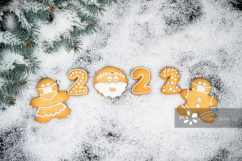 圣诞背景姜饼在冬天的雪。假期心情卡。俯视图，复制空间。家庭传统，DIY，庆祝概念。节日背景与自制姜饼饼干。图片素材