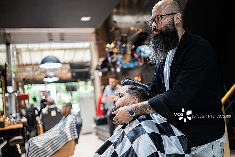 一个中年男子在理发店和理发师交谈图片素材