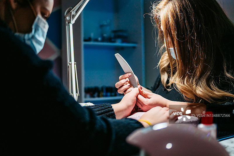 美容师在美容院给顾客做指甲图片素材