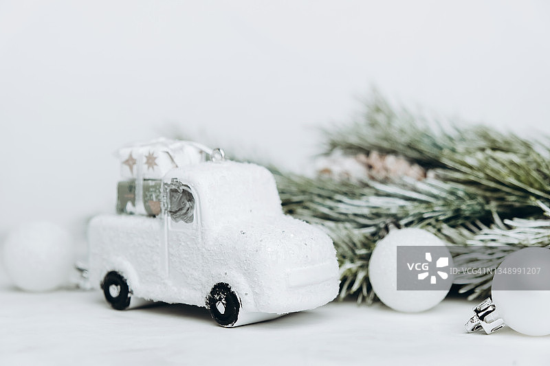 小型汽车与白色圣诞玩具在浅色背景。图片素材