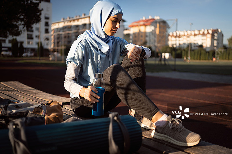 现代穆斯林女运动员测量她的脉搏图片素材