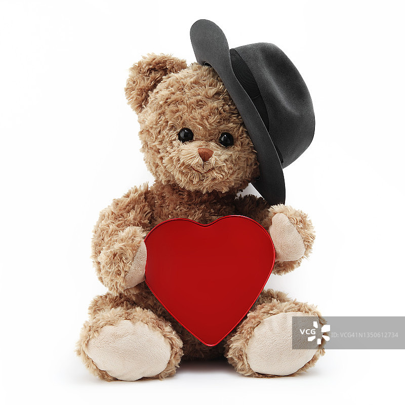 有趣的泰迪熊与帽子和红色的心孤立在白色的背景图片素材