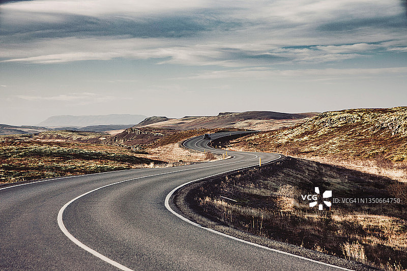 汽车行驶在冰岛风景曲折的道路上。图片素材