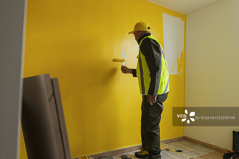 工人把房子漆成黄色，以便移交给新主人图片素材