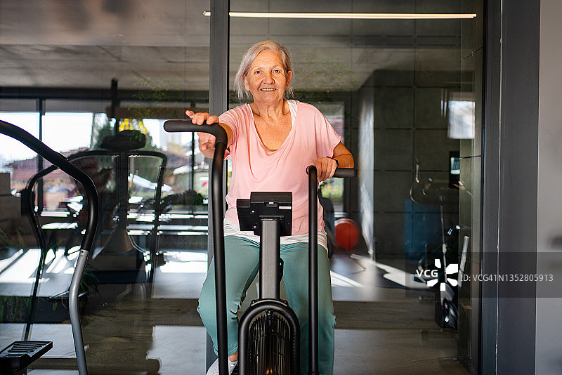 一位老妇人在健身房锻炼身体图片素材