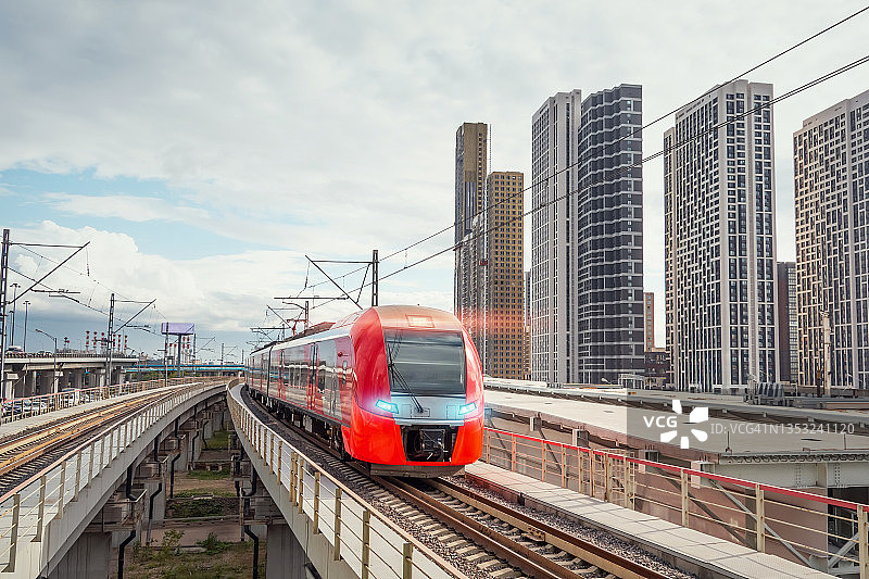 电动客运列车在现代城市景观中高速行驶。图片素材