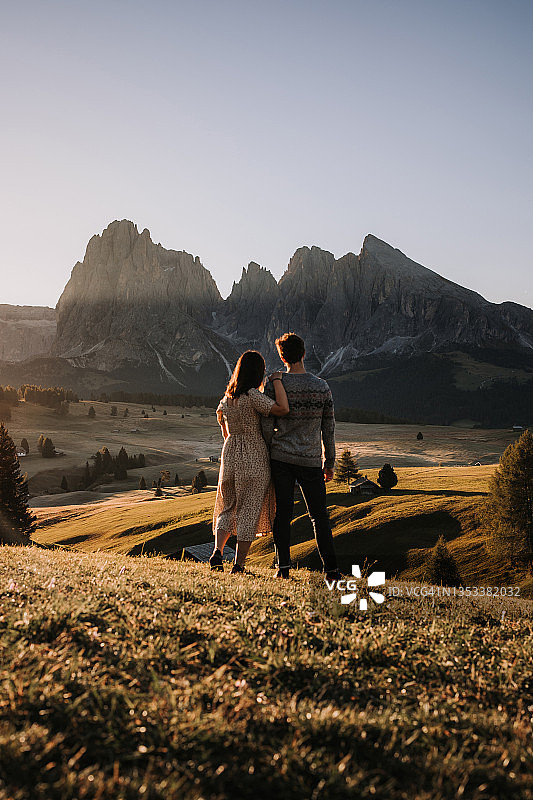 日出时阿尔卑斯山上的年轻夫妇图片素材