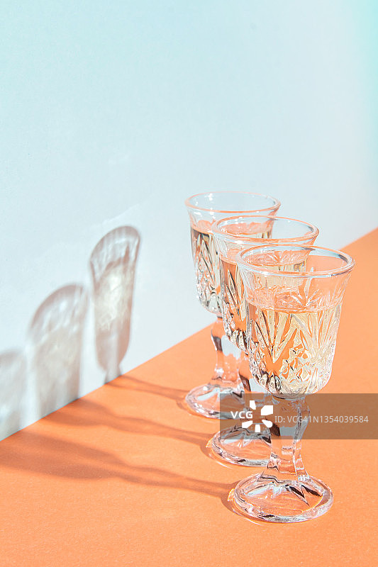 香槟酒杯，亮橙色背景。色彩丰富的极简主义艺术构图。圣诞节和新年的概念，生日节日派对。图片素材
