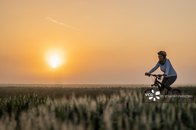 女人骑自行车在田野图片素材