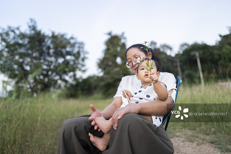 亚洲妈妈穿着休闲的衣服和女儿休闲野餐户外家庭正常的生活方式图片素材
