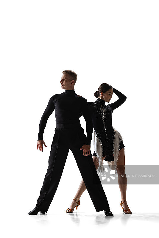 两个年轻优雅的舞者，灵活的男人和女人跳舞交际舞隔离在白色工作室的背景。图片素材