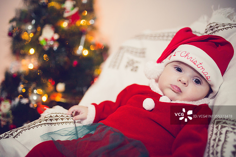 婴儿在圣诞树前休息图片素材