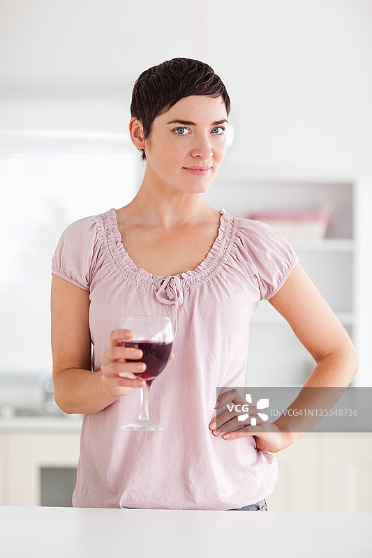 拿着一杯酒对着镜头的女人图片素材