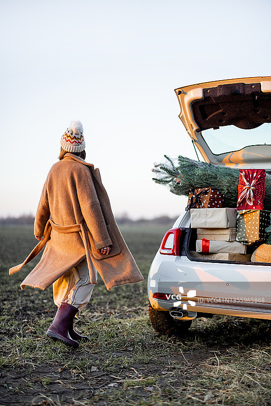 女人和一辆装满新年礼品盒的车图片素材