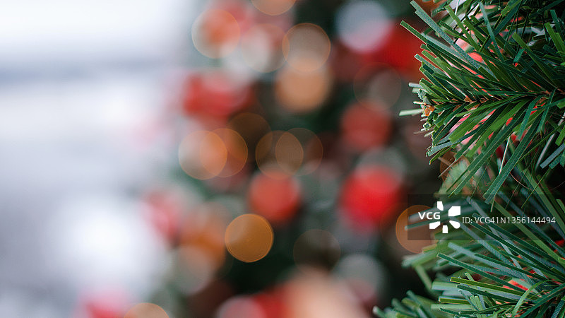 模糊的彩灯的花环和圣诞树的树枝在前景。圣诞节和新年背景。图片素材