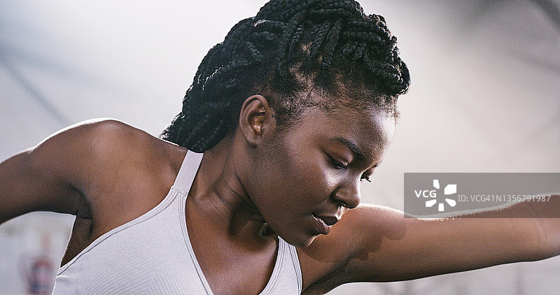 一个年轻健康的女人在健身房锻炼前做热身伸展运动的照片图片素材