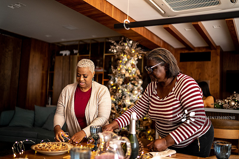 母亲和女儿在家里准备圣诞午餐或晚餐图片素材